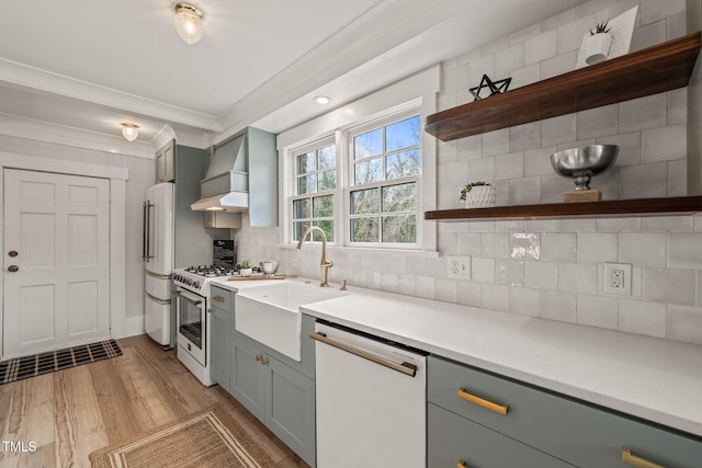 kitchen with sink, light hardwood / wood-style flooring, backsplash, crown molding, and white appliances