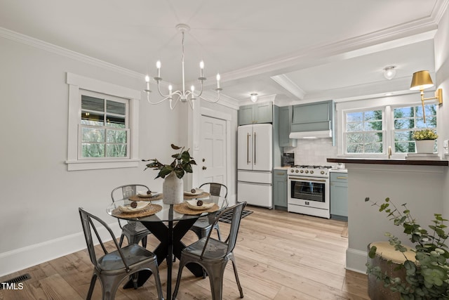 dining room with beam ceiling, crown molding, an inviting chandelier, and light wood-type flooring