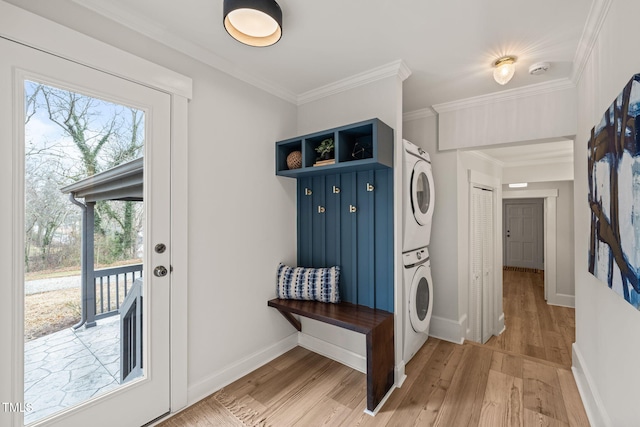 mudroom featuring crown molding, stacked washer / dryer, and light hardwood / wood-style flooring