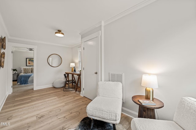 living area with crown molding and light wood-type flooring