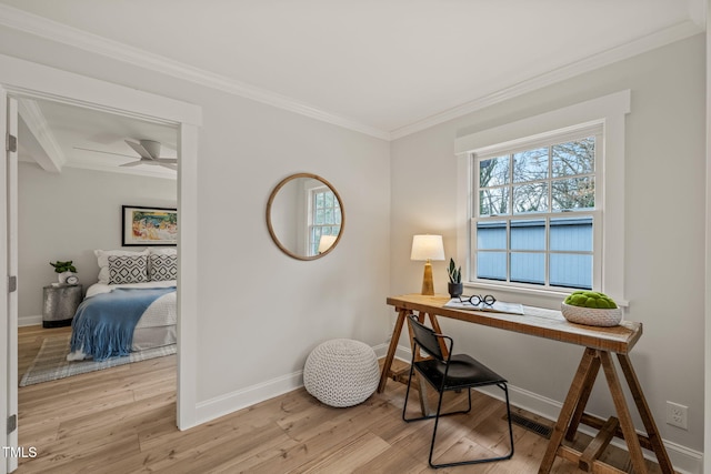 office space featuring beam ceiling, ceiling fan, ornamental molding, and light wood-type flooring