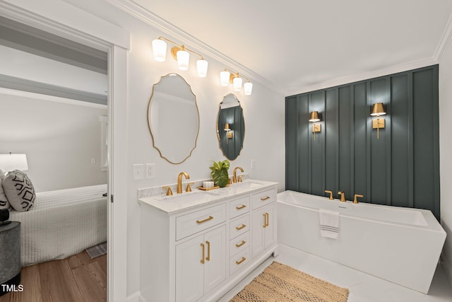 bathroom with a bath, crown molding, vanity, and wood-type flooring