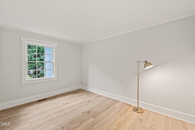 empty room with light wood-type flooring and crown molding