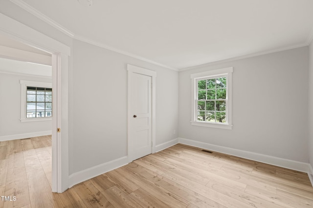 spare room with light wood-type flooring and ornamental molding