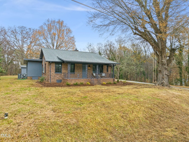 ranch-style house featuring covered porch and a front lawn