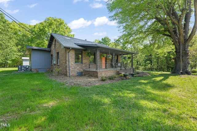 view of home's exterior featuring brick siding, a yard, and covered porch