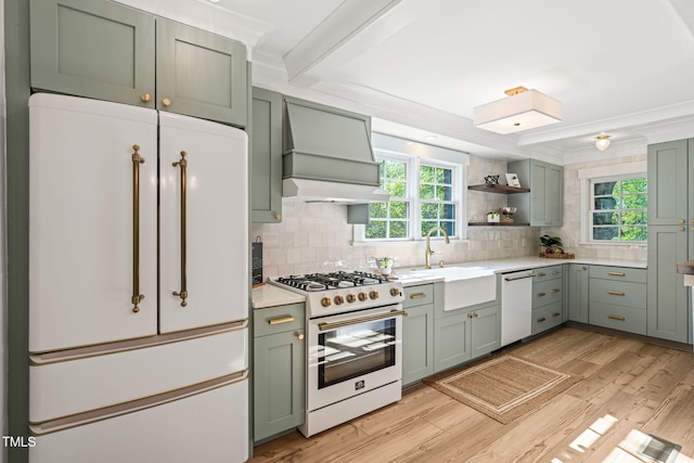 kitchen featuring green cabinetry, custom exhaust hood, a sink, and white appliances