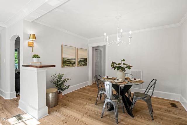 dining area with an inviting chandelier, light wood-style flooring, arched walkways, and crown molding