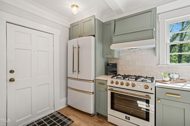 kitchen with light countertops, white appliances, backsplash, and green cabinetry
