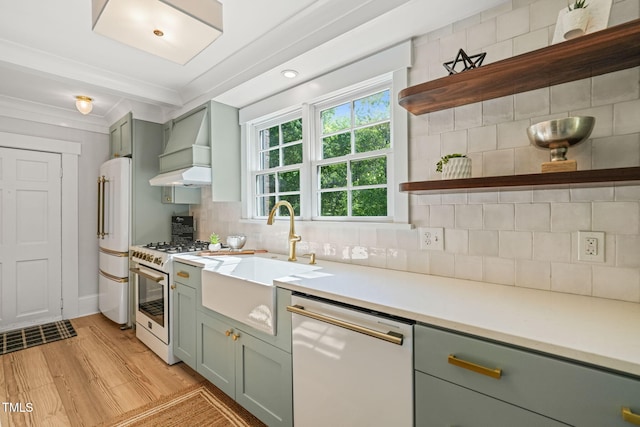 kitchen featuring custom exhaust hood, open shelves, a sink, white appliances, and green cabinetry