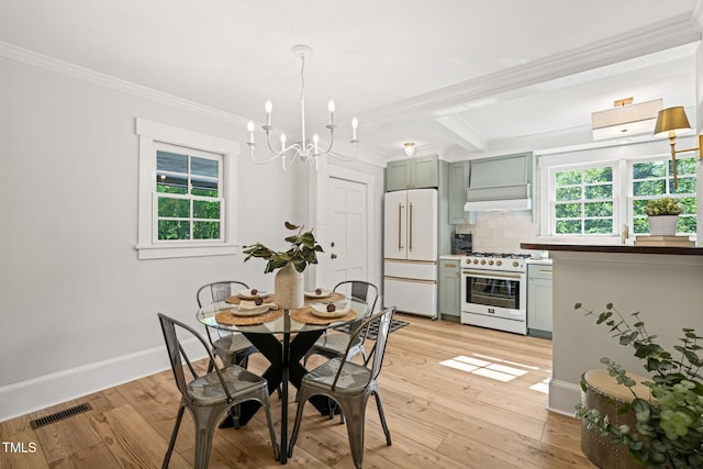 dining room featuring an inviting chandelier, visible vents, ornamental molding, light wood-style floors, and baseboards