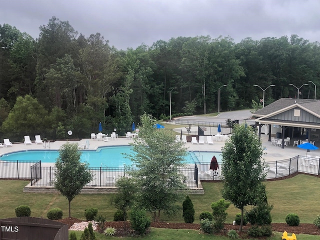 view of pool featuring a yard and a patio