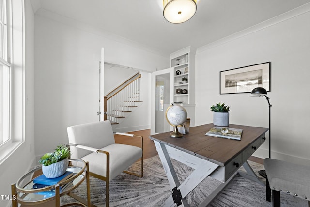 office space with built in shelves, crown molding, and wood-type flooring