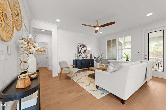 living room featuring ceiling fan, wood-type flooring, and crown molding