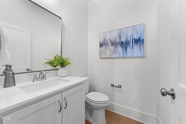 bathroom featuring vanity, hardwood / wood-style flooring, and toilet