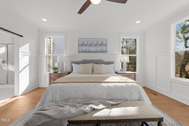 bedroom with light wood-type flooring, ceiling fan, and ornamental molding