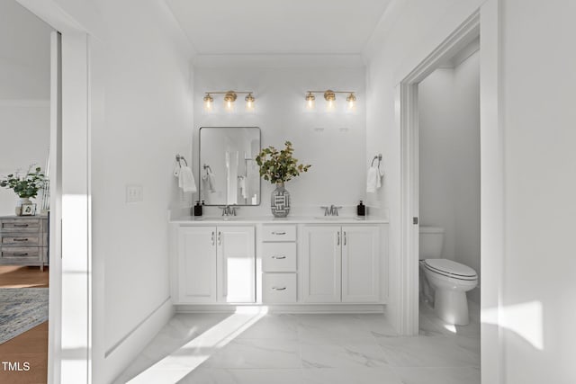 bathroom with vanity, toilet, and crown molding