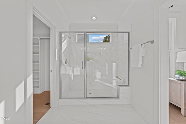 bathroom featuring a shower with shower door and ornamental molding