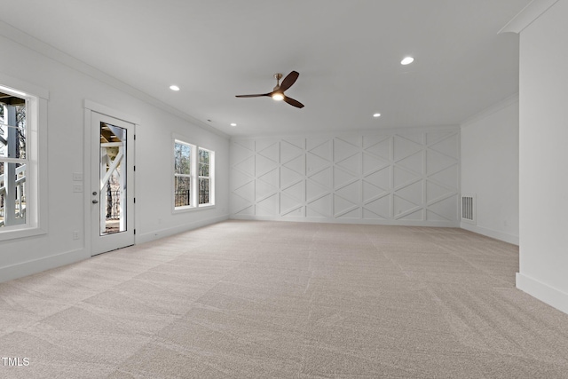 carpeted spare room with ceiling fan and ornamental molding