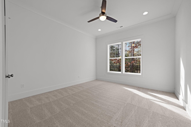 carpeted spare room featuring ceiling fan and crown molding