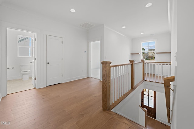 corridor featuring light hardwood / wood-style floors and crown molding