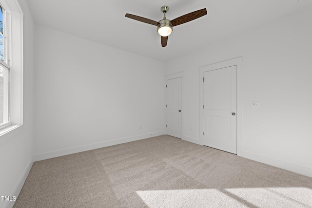 carpeted spare room featuring ceiling fan