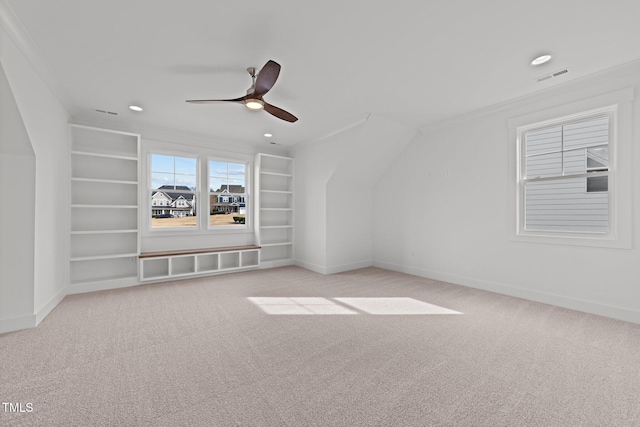 additional living space with ceiling fan, built in features, and light carpet