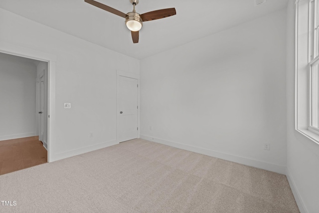 empty room featuring ceiling fan and light colored carpet