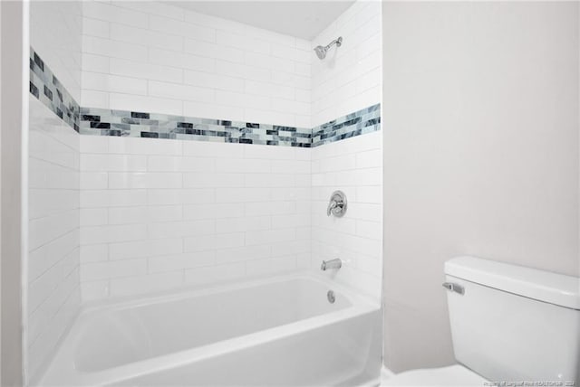 bathroom with toilet and tiled shower / bath combo