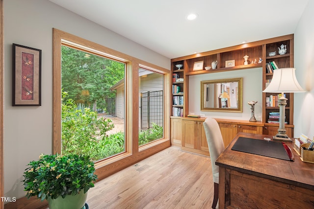 office area with built in features and light hardwood / wood-style flooring