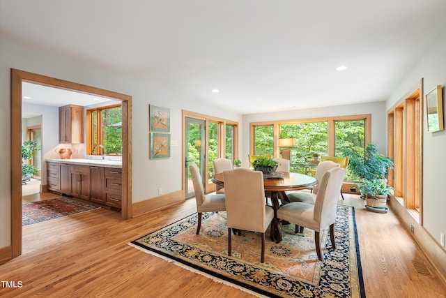 dining space featuring sink and light wood-type flooring