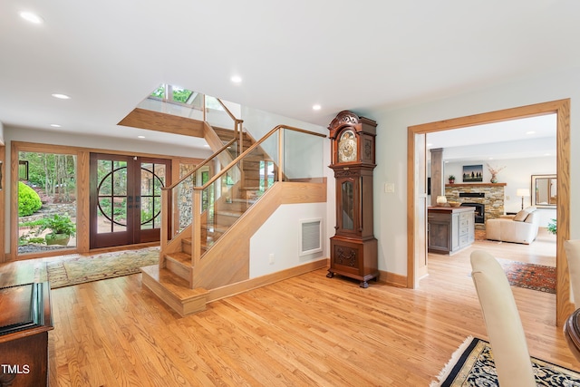 stairway with hardwood / wood-style flooring, a fireplace, and french doors