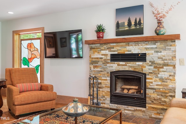 living room featuring a stone fireplace