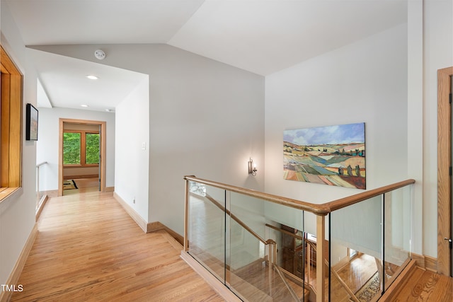 corridor featuring vaulted ceiling and light hardwood / wood-style flooring