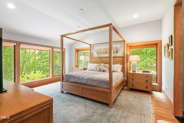 bedroom featuring lofted ceiling and light hardwood / wood-style floors