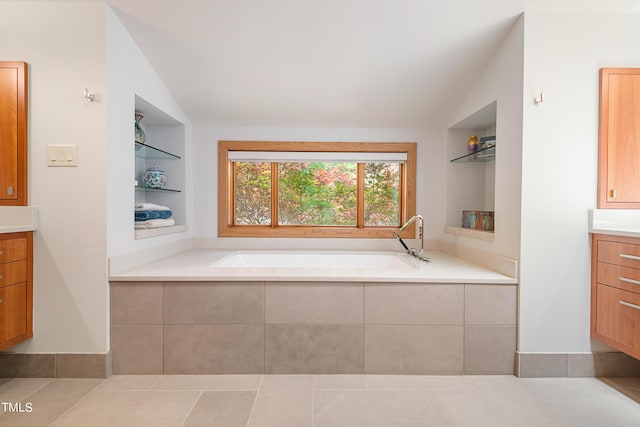 bathroom featuring built in shelves, lofted ceiling, vanity, and a bath