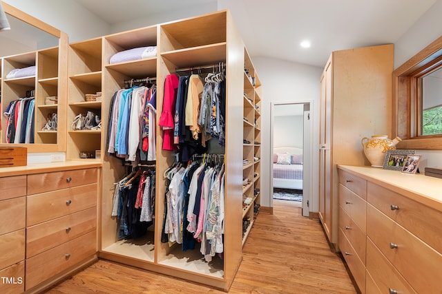 spacious closet with vaulted ceiling and light hardwood / wood-style floors