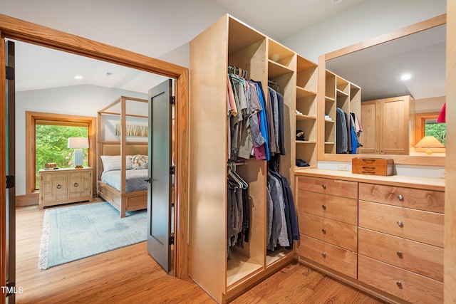 spacious closet featuring vaulted ceiling and light hardwood / wood-style floors