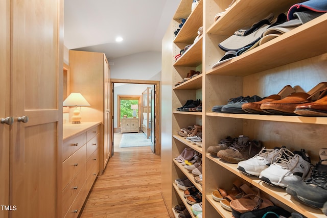 walk in closet featuring vaulted ceiling and light hardwood / wood-style flooring