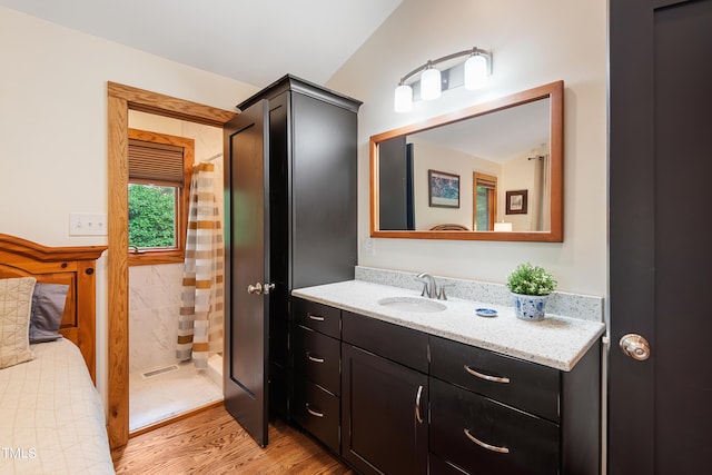 bathroom featuring hardwood / wood-style flooring, vanity, and walk in shower