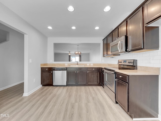 kitchen with decorative backsplash, light wood-type flooring, dark brown cabinets, stainless steel appliances, and sink