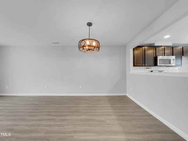 unfurnished dining area featuring light wood-type flooring