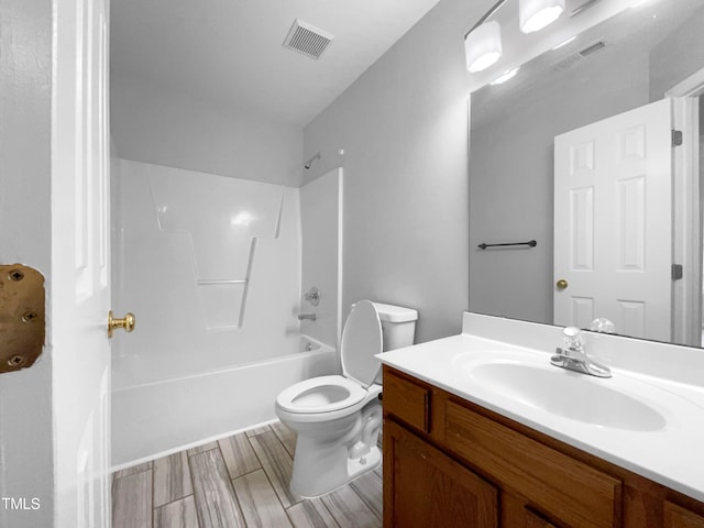 full bathroom featuring vanity, hardwood / wood-style flooring, toilet, and shower / washtub combination