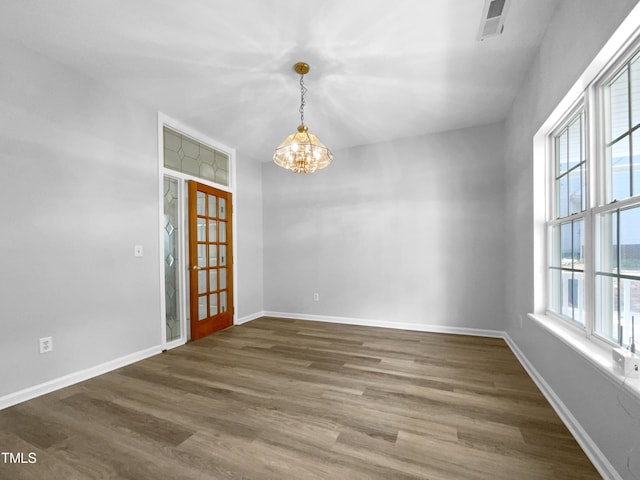 unfurnished room featuring dark hardwood / wood-style flooring and a chandelier