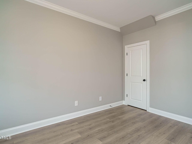 spare room with ornamental molding and light wood-type flooring