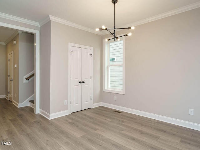 interior space featuring hardwood / wood-style floors, crown molding, and a notable chandelier