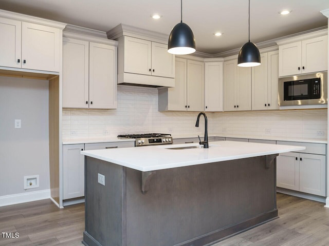 kitchen featuring pendant lighting, decorative backsplash, stainless steel appliances, and hardwood / wood-style flooring