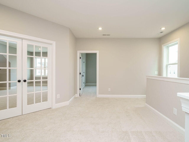 unfurnished room with french doors and light colored carpet