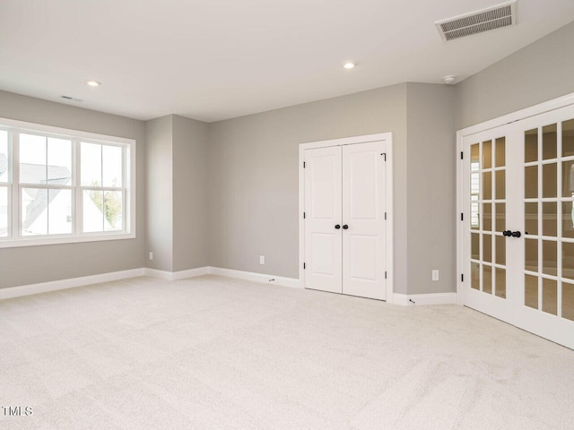 unfurnished room with french doors and light colored carpet