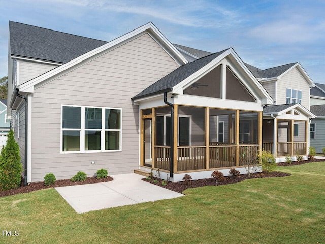 rear view of house with a yard, a patio, and a sunroom